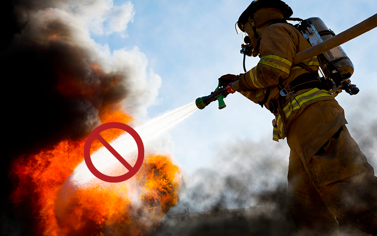 Firefighter spraying water into a natural gas fire